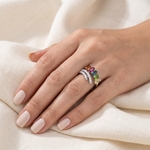 Hand model wearing natural tourmaline five-stone ring in sterling silver on cream linen