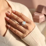 Close-up of Natural Opal Ring - Arcana Aurora worn on hand against cream knit