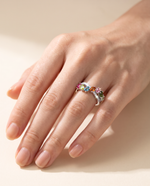 Close-up of hand wearing natural tourmaline and diamond crossover ring