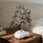 Garnet crystal tree on a bedside table in soft morning light