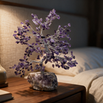 Amethyst crystal tree on a bedside table in warm evening light