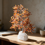 Carnelian crystal tree on a work desk in bright morning light