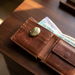 Pyrite Zibu coin carried in a wallet beside banknotes