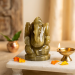 Cat's eye Ganesha in pooja corner with brass diya and marigold